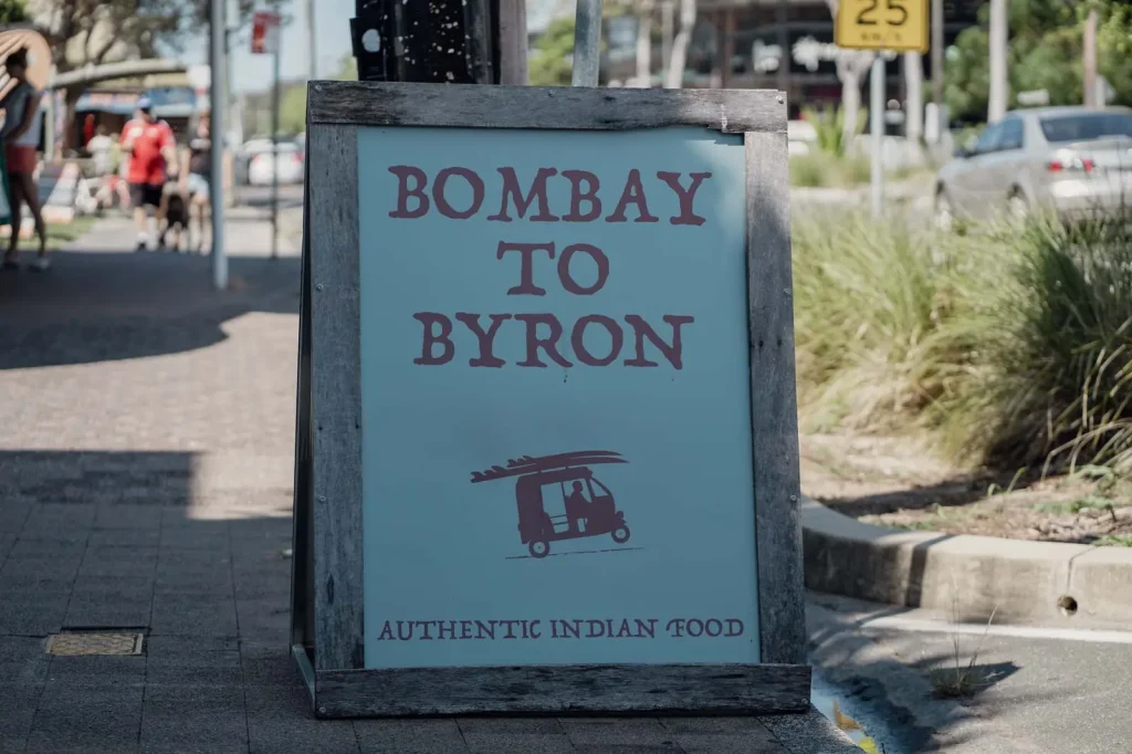 Bombay to Byron A-frame sign on the footpath in Byron Bay